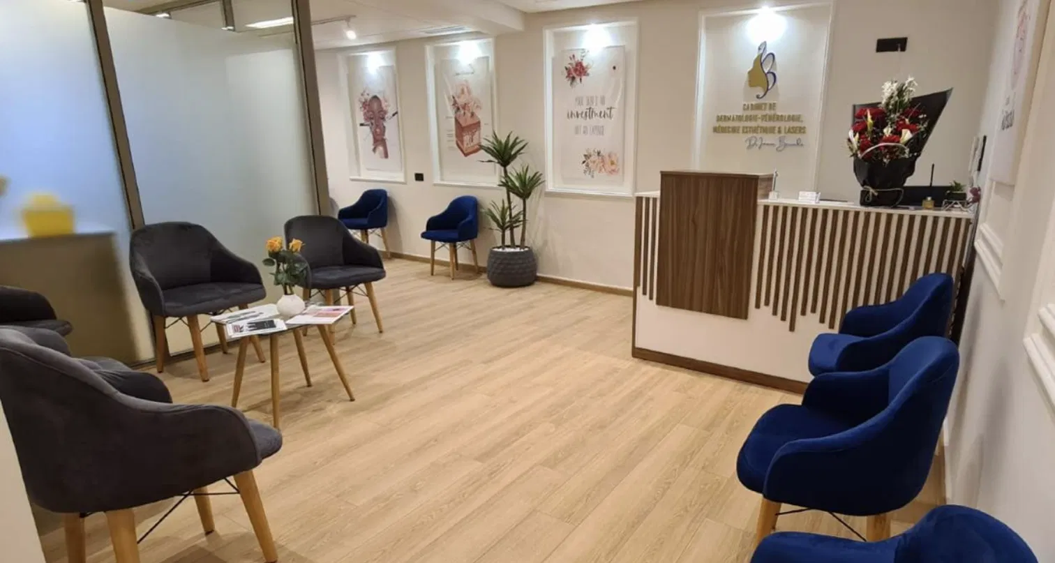 Salle d'attente du cabinet — fauteuils velours marine, parquet chêne, atmosphère sereine